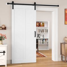 an open white sliding door in a living room next to a dresser and bookcase