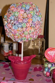 there is a candy tree on the table with pink flowers and lollipops