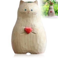 a wooden cat with a red heart on its chest and an ornament in the shape of a cat