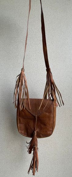 Vintage leather bag African vintage leather Full Length: 36 inches Width: 9 inches Vintage Leather Bags With Fringe, Leather Satchel With Tassels, Leather Shoulder Bag With Tassels For Travel, Leather Satchel Shoulder Bag With Tassels, Leather Satchel With Tassels For Travel, Leather Satchel With Tassels As Shoulder Bag, Brown Satchel Shoulder Bag With Tassels, Rectangular Brown Satchel With Tassels, Leather Travel Shoulder Bag With Tassels