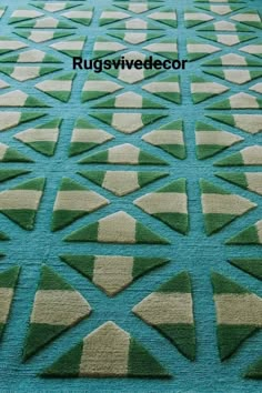 a blue rug with green and beige geometric shapes on the carpet is shown in full view