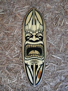 a skateboard with an angry face painted on it's side sitting in the grass