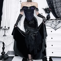 a woman dressed in gothic clothing posing for the camera