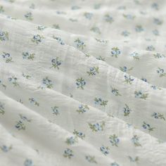 closeup of white fabric with blue flowers on it