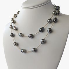 Introducing our exquisite Tahitian Pearl Station Long Necklace, a testament to refined elegance in modern jewelry design. This piece artfully marries the timeless allure of pearls with the luxurious warmth of 14K yellow gold, creating an accessory of modern sophistication. The necklace is 36 inches in length and weighing 46.5 grams, is crafted with meticulous attention to detail. It can be worn long for a more dramatic look, or wrapped double. It features semi-baroque and circled drops Tahitian Elegant Yellow Gold Tahitian Pearl Jewelry, Elegant Gold Tahitian Pearl Jewelry, Formal Tahitian Pearl Necklace In Yellow Gold, Formal Yellow Gold Tahitian Pearl Necklace, Elegant Tahitian Pearl Necklace For Formal Occasions, Elegant Tahitian Pearl Necklace With High Luster, Elegant Tahitian Pearl Jewelry With Round Beads, Classic Gold Tahitian Pearl Necklace, Elegant Single Strand Tahitian Pearl Necklace