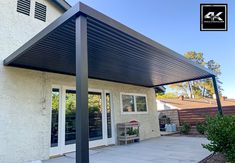 a patio covered in black metal with sliding glass doors