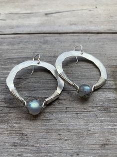 "1.75\" sterling silver hand-forged hoops wrapped with a flashy labradorite. Oxidized silver or plain silver finish. You choose at checkout ! 2.25\" drop from hypoallergenic niobium earwires. Handmade in NY" Bohemian Hand Forged Sterling Silver Earrings, Artisan Silver Round Hoop Earrings, Handmade Sterling Silver Dangle Wrap Earrings, Bohemian Sterling Silver Wire Wrapped Earrings, Artisan Handmade Silver Hoop Earrings, Hammered Freeform Jewelry As A Gift, Hammered Freeform Jewelry For Gifts, Handmade Bohemian Sterling Silver Wrap Earrings, Hand Forged Bohemian Hoop Jewelry