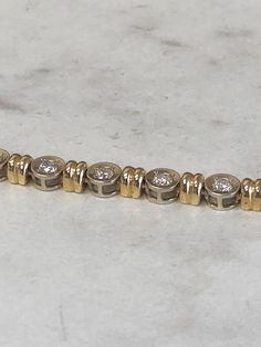 "14kt Yellow and White Gold Tow-Tone Lady's Diamond Bracelet 7\" in length with 15 full cut round brilliant diamonds 3.50ct total weight, SI1 clarity, G color all prong set in 14kt White Gold Bezel settings alternating with 14kt Yellow Gold roundels all hinged for great flexibility and comfort. The bracelet has a box style clasp with a secure fig 8 safety clasp and has a total weigh of 21.5 grams. This item would Retail for $10,550.00" Channel Set Round Cut Diamond Bracelet, Channel Set Diamond Bracelet For Anniversary, Yellow Gold Channel Set Diamond Bracelet, Timeless Channel Set Tennis Bracelet For Anniversary, Channel Set Diamond Bracelet In Fine Jewelry Style, Fine Jewelry Diamond Bracelet With Channel Set, Anniversary Diamond Bracelet Channel Set, Formal Yellow Gold Tennis Bracelet Channel Set, Formal Yellow Gold Channel Set Tennis Bracelet