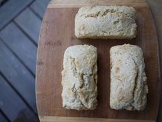 four pieces of bread sitting on top of a wooden cutting board