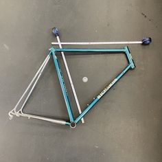 a blue bicycle frame laying on the ground