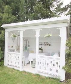 a white gazebo sitting on top of a lush green field