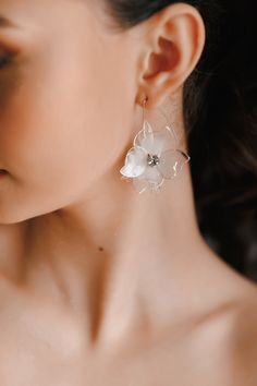 a close up of a person wearing earrings with flowers on it's ear posts