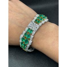 This is part of Chairish’s Fine Jewelry assortment.  This Art Deco Emerald Diamond Wedding Bracelet in 18K gold showcases 40 endlessly sparkling natural emerald, weighing 23.74 carat and diamonds weighing 7.09 carat. It measures 7.5 inches long in length.  Emerald enhances the intellectual capacity of the person. Designed with perfect oval cut emerald set horizontally in between the diamonds with diamond charm in center to make you stand out on any occasion or event. The elegant style complements the attire beautifully and this is a perfect Unique Gift, Bridal Shower Gift, Secret Santa Gift, Gift For Sister, Mother Daughter Gift, Bride To Be Gift, Bridesmaid Gift, Thanksgiving Gift, Anniversary Present, Christmas Gift or any Holiday Gift for Mother, Sister, Daughter, Grandma, Fiancé, Girlf Luxury Emerald Cut Green Diamond Bracelet, Luxury Green Diamond Bracelet Hand Set, Luxury Green Brilliant Cut Diamond Bracelet, Luxury Green Hand Set Diamond Bracelet, Luxury Emerald Gemstone Tennis Bracelet, Luxury Round Emerald Bracelets, Green Diamond Bracelet For Formal Occasions, Green Diamond Bracelet With Brilliant Cut, Green Diamond Bracelets With Brilliant Cut