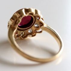 This dramatic ring demand an evening on the town. 0.67 carats of hand faceted diamonds are paired with an oversized cabochon garnet and set in 14k gold.Ring size ranges from 5-8. Timeless Diamond Rings With Cabochon, Luxury Garnet Ring With Center Stone, Elegant Amethyst Ring With Rose Cut Diamonds, Formal Round Garnet Cluster Ring, Formal Garnet Ring With Center Stone, Elegant Ruby Cluster Ring With Rose Cut Diamonds, Formal Garnet Gemstone Diamond Ring, Formal Garnet Gemstone Cluster Ring, Elegant Ruby Ring With Bezel Setting