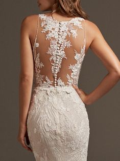 the back of a wedding dress with an open back and floral appliques on it