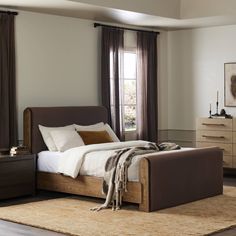 a bedroom with a bed, dressers and window in it's center area