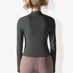 the back view of a woman wearing a black wetsuit with grey and pink panels