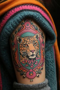 a woman's arm with a tattoo on it that has a leopard in the center