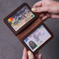 a woman is holding an id card in her wallet