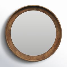 a round wooden mirror hanging on the wall