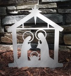 a metal nativity scene with a baby jesus in the manger, surrounded by stars