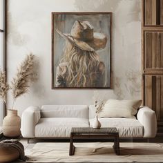 a living room with a white couch and a painting on the wall above it's head