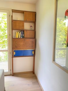 an empty room with a book shelf and mirror