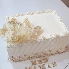 a white cake with gold decorations on top and the words happy mamma written in gold