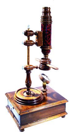 an old fashioned microscope with glass beads on it's top and bottom part, in front of a white background