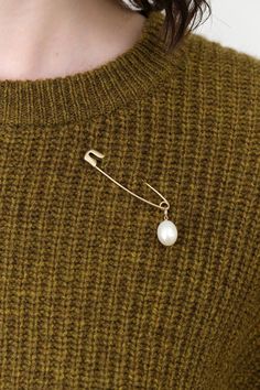 The Pearl Safety Pin Brooch is a stunning accessory that marries contemporary design with timeless beauty. This brooch showcases a lustrous freshwater pearl gracefully suspended from a large safety pin, offering a unique twist to your hairstyles or outfits. Perfect for those who appreciate a touch of sophistication, this brooch adds a radiant shimmer to any look. Safety Pin Accessories, Elegant Safety Pin Brooch, Wedding Brooch In Safety Pin Shape, Brooch Styling, Brooch Aesthetic, Large Safety Pin, Safety Pin Brooch, Best Eyeliner, Tassel Scarf