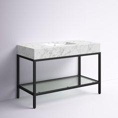 a white marble sink sitting on top of a black stand