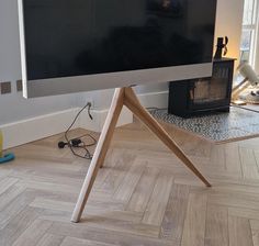 a flat screen tv sitting on top of a wooden stand in front of a window