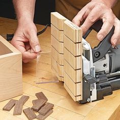 a person using a planer to cut wood pieces with a jig saw on a table