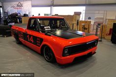 an orange truck parked inside of a garage