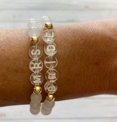 This is the perfect bride to be gift! This natural white jade bracelet is so beautiful with the gold beads + clear letter beads. Each bracelet will arrive individually packaged in an organza bag ready to gift! Bracelets have gold filled beads and won't tarnish. Gold filled is the best + most affordable option after real gold. Please check all selections and spelling prior to check out. Our custom bracelets are made to order so all sales are final. Receipts are never included in your package. If Customized White Round Bracelets, Dainty White Round Charm Bracelet, Adjustable Gold Charm Bracelet For Wedding, Dainty White Bracelets For Anniversary, Elegant White Bracelet For Bridal Shower, Dainty White Bracelet For Anniversary, Personalized Adjustable Crystal Bracelet For Wedding, Adjustable Charm Bracelet With Round Beads For Wedding, Adjustable White Pearl Bracelet For Anniversary