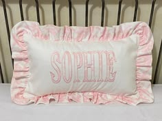 a white pillow with pink ruffles and the word sopple on it