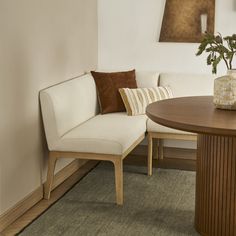 a white couch sitting next to a wooden table on top of a carpeted floor