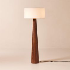 a wooden lamp with a white shade on the top and a cord attached to it