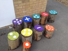 colorfully painted wooden stumps sitting in front of a brick building