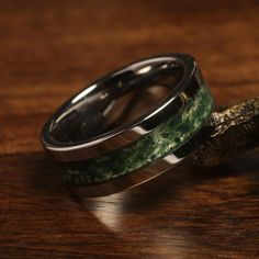 two wedding bands with green and black marble inlays on top of each other