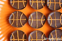 chocolates are arranged in the shape of basketballs on an orange tray with white and brown icing