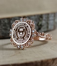 a close up of a ring on top of a piece of wood with an emblem