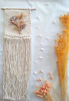 two pieces of art that are on a white surface with dried flowers and grass in the foreground