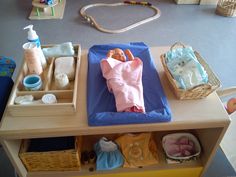 a baby's diaper and other items are on a wooden table in a playroom