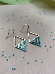 Dive into the bliss of summer with our 'Aegean Breeze Triangle Earrings'. Handcrafted with love and precision, each earring features a Stainless Steel Gold link that anchors a refreshing blend of turquoise blue, aqua blue, and bronze Miyuki beads. Utilizing the ancient technique of bead weaving, specifically brick stitch, this design mirrors the allure of ocean waves and the warmth of summer skies. Mirroring the allure of ocean waves and the warmth of summer skies these triangle earrings elevate Blue Triangle Earrings For Gift, Minimalist Sterling Silver Earrings For Summer, Bohemian Triangle Adjustable Earrings, Bohemian Adjustable Triangle Earrings, Adjustable Bohemian Triangle Earrings, Tiny Beads Drop Earrings For Gifts, Bohemian Earrings With Dangling Beads For Everyday, Bohemian Triangle Jewelry With Dangling Beads, Turquoise Teardrop Earrings With Tiny Beads