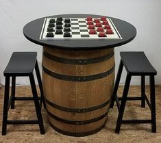 a chess board on top of a barrel with stools next to it and a table