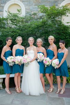 a group of women standing next to each other holding bouquets