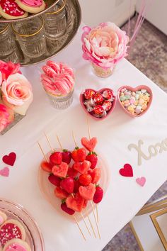 a table topped with lots of desserts and cupcakes on top of it