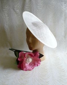 "One contoured saucer with a slight upturned brim hat sinamay straw fascinator / hat base in ivory that measures approximately 13\" in diameter. The base is contoured to fit against the head. The edges of the brim are finished in sinamay. The multi-layer stiffened sinamay straw has a great sturdy weave and provides excellent support for your millinery creations. This is NOT a finished hat and will not stay on your head unless you add a head band to wear. Add embellishments of your choice. A nice Classic Cream Fitted Top Hat, Classic White Fascinator, Fitted White Brimmed Costume Hat, Fitted White Hat With Curved Brim, Classic White Mini Hat With Curved Brim, White Classic Mini Hat With Curved Brim, White Fitted Hat With Curved Brim, Classic Fitted Cream Boater Hat, Adjustable White Mini Hat With Curved Brim