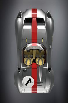 the rear end of a silver sports car with red stripes on it's side